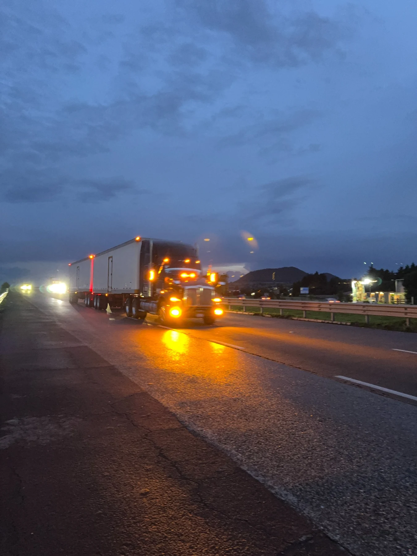 Luces de una unidad RAV sobre la carretera mojada